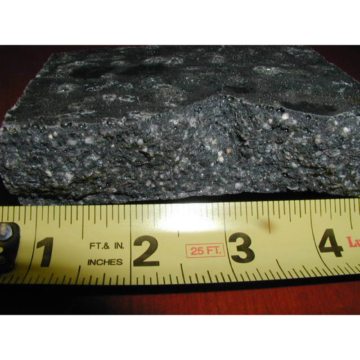 Heavily Loaded: A sample of heavily loaded resin shows the abundance of aggregate. This makes the nosing material very dry, very hard, very brittle, and very likely to fail under snow-plow impact, deflection of the deck, and differential expansion in relation to the concrete and/or simply as a consequence of normal traffic over time.
