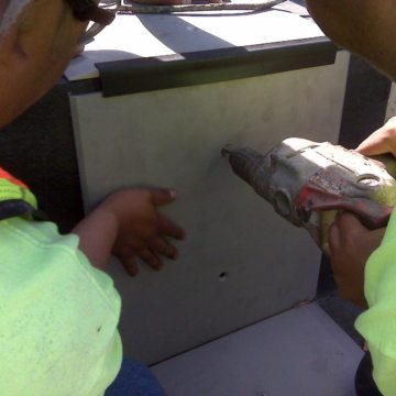 Attaching vertical riser cover plates. A factory-installed custom extrusion makes the transition between the tread and riser plates