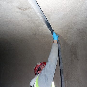 The EMSEAL-supplied epoxy is hand-troweled onto the concrete and fireproofing joint faces.