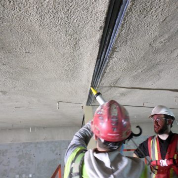 A finishing band of injected liquid silicone seals the silicone bellows to the fireproofing substrate.