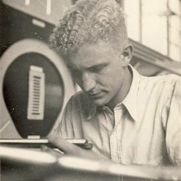 Peter Hensley working as aeronautical engineer using a slide rule to make measurements.