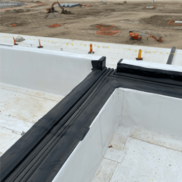 Waterproof roof to wall expansion joint scupper transition to vertical exterior wall joints
