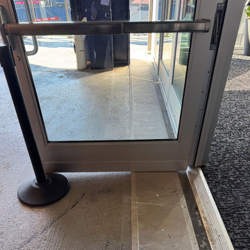 Expansion joint cover plate running under open stadium door.