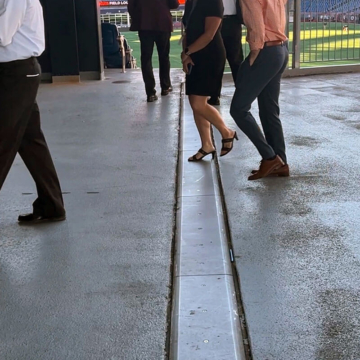 High heels stepping on expansion joint cover plate on concourse.