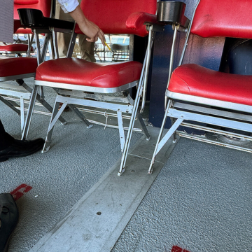 Sika Emseal team examining a coverplate installed over a stadium expansion joint system under seating loads to evaluate performance and durability.