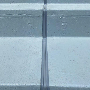 Non-invasively anchored stadium expansion joint DSM System installed in epoxy-coated treads and risers