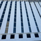 Multi-story hotel facade with vertical expansion joint system Seismic Colorseal-DS installed between exterior wall sections.