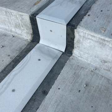 Close-up of the 90-degree vertical transition in the Ryan Field expansion joint, showing the factory-fabricated coverplate carrying the seal through the direction change without a break.