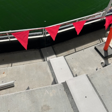 Expansion joint running along the perimeter wall bordering the playing field at Ryan Field, marked with red safety flagging during construction.
