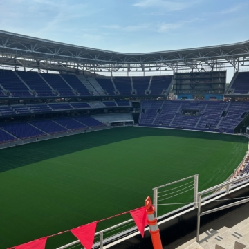 Overview of Ryan Field's seating bowl under construction, with red flags marking expansion joint locations along the upper concourse edge.