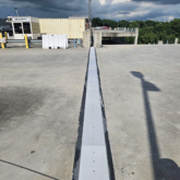 SJS expansion joint system spanning the width of a concrete parking deck at ATL's Rental Car Center.