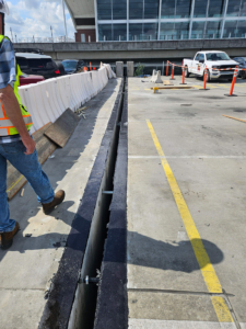 Crew preparing to install SJS expansion joint sections into a parking structure deck joint at the Rental Car Center.